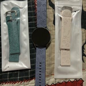 Samsung Galaxy Watch 7 with watch bands and charger